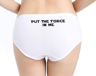May include: White underwear with the text "PUT THE FORCE IN ME" printed in black across the back. The underwear is a classic brief style.