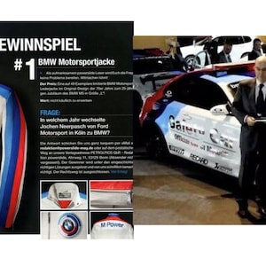 May include: A white leather jacket with blue, red and white stripes on the sleeves. The jacket has a BMW logo on the chest and the words "M Power" on the back. The jacket is displayed on a white background with text in German.