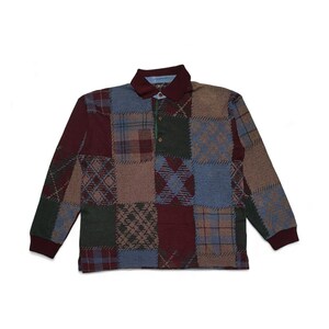May include: Long-sleeved patchwork polo shirt. The shirt has a patchwork design with various patterns in burgundy, green, blue, and tan. It features a burgundy collar and cuffs, and a three-button placket.