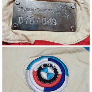 May include: A white leather jacket with a silver metal plate that says "25 Jahre BMW M5. 010/049" and a blue, red and white embroidered BMW logo.
