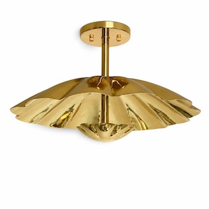 May include: A semi-flush mount ceiling light fixture with a polished gold finish. The fixture features a central vertical rod attached to a circular canopy and a wide, scalloped, petal-like shade that flares outward with a reflective surface.