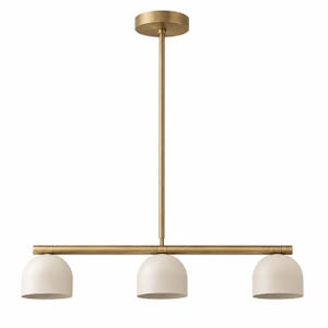 Puede incluir: Una moderna lámpara colgante de tres luces. La lámpara tiene un acabado de latón con tres pantallas en forma de cúpula de color blanquecino. La luz cuelga de una varilla de latón y un soporte de techo circular.