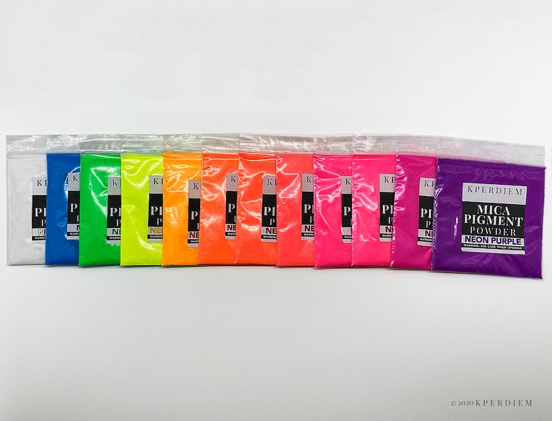 May include: A set of 13 small plastic bags containing neon mica pigment powder. The colors include white, blue, green, yellow, orange, red, pink, magenta, purple, and neon purple. The bags are labeled with the text "KPERDIEM MICA PIGMENT POWDER NEON PURPLE".