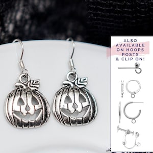 May include: Silver pumpkin earrings with a jack-o'-lantern face. Also available in hoop, post, and clip-on styles.