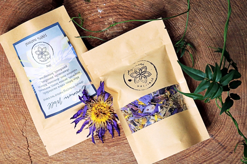 May include: Two brown paper bags with a clear window showing dried herbs and flowers inside. The bags are labeled "Dream Well" and "100% natural".