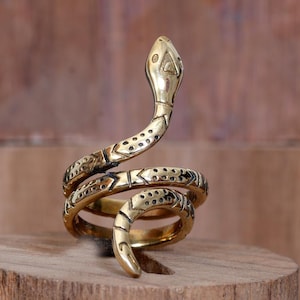 May include: A gold-toned snake ring with a coiled design. The snake's head is raised and has a detailed face.