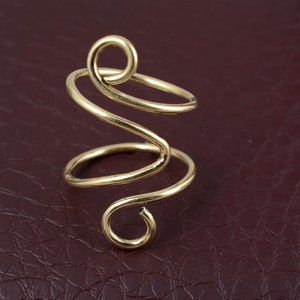 Puede incluir: Un anillo de alambre de color dorado en forma de espiral.