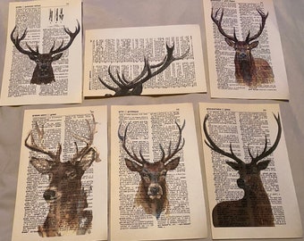 May include: Six vintage dictionary pages with watercolor illustrations of deer heads. The pages are printed with black text and have a cream background.