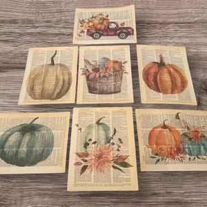 Puede incluir: Seis impresiones de arte imprimibles con ilustraciones de temática otoñal de calabazas, calabacines y un camión rojo que lleva calabazas. Las impresiones están impresas en páginas de diccionarios antiguos.
