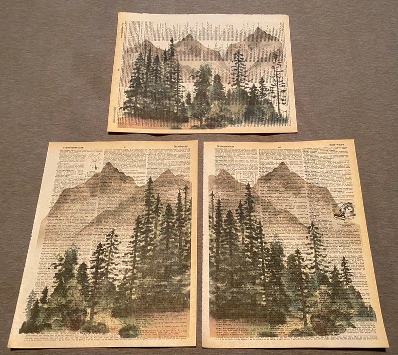 Pu&ograve; includere: Tre pagine di dizionario vintage con illustrazioni ad acquerello di montagne e alberi. Le pagine sono stampate con testo nero e hanno un aspetto ingiallito e invecchiato.