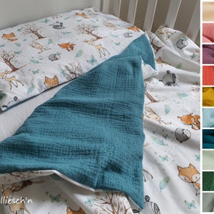 Puede incluir: Un juego de cama para cuna con funda n&oacute;rdica y funda de almohada blancas con estampado de animales del bosque, incluyendo zorros, ciervos y conejos. El juego incluye una manta de muselina azul turquesa. La ropa de cama est&aacute; dise&ntilde;ada para un beb&eacute; o ni&ntilde;o peque&ntilde;o.