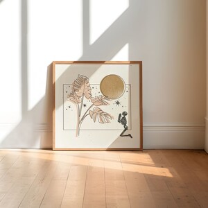 Op de afbeelding: Een ingelijst print met een minimalistische illustratie van een skelet dat knielt voor een grote, gouden maan. Het skelet wordt omringd door gestileerde bladeren en sterren.