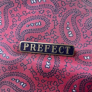 Vintage gold tone and enamel old school Prefect brooch/badge.