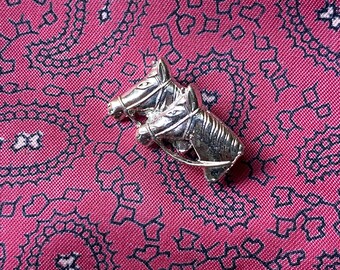 Vintage silver tone stock pin brooch featuring a pair of horses.