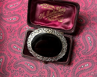 May include: A black onyx cameo set in a silver Celtic knot design, in a red velvet box with the inscription "Watchmakers & Jewellers A. Marks & Sons 10 Bigg Market Newcastle on Tyne".