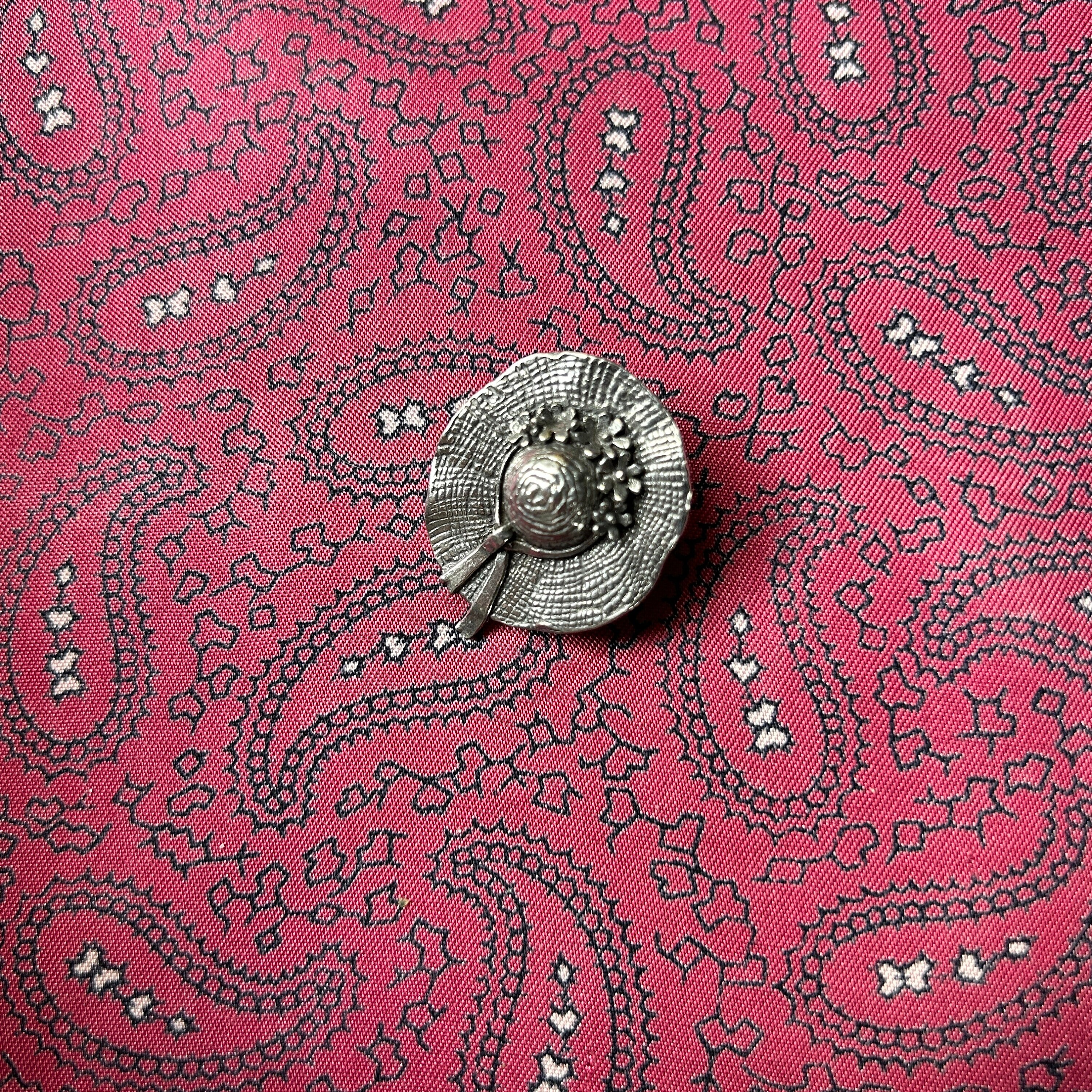 Vintage pewter brooch in a pretty straw bonnet design with flowers and ribbon.