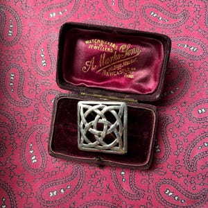 May include: A silver Celtic knot brooch in a red velvet box. The box is labeled "Watchmakers & Jewellers A. Marks & Sons 40 Bigg Market Newcastle on Tyne."