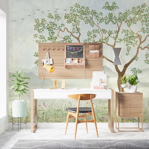 May include: A white desk with a wooden chair, a wall-mounted wooden organizer with a chalkboard, and a small wooden cabinet. The wall features a mural of a large tree with green leaves and birds against a light blue background with a meadow.