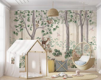 May include: A wall mural featuring a forest scene with trees, green leaves, a deer, a squirrel, and birds. The room includes a white house-shaped play tent, a hanging wicker chair with a blue cushion, a yellow bin, and a gray storage basket.