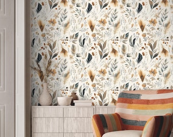 Puede incluir: Papel pintado con un patrón repetitivo de elementos botánicos que incluyen hojas, flores y plumas en tonos marrón y gris oscuro sobre un fondo crema. Un mueble de madera clara se sitúa debajo con un jarrón, un cuenco y un sillón a rayas.