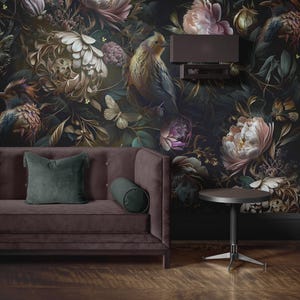 Può includere: Una scena di soggiorno con una carta da parati floreale scura con uccelli, farfalle e grandi fiori nei toni del marrone, verde e rosa. Un divano color prugna con cuscini verdi e un tavolino completano l'arredamento.