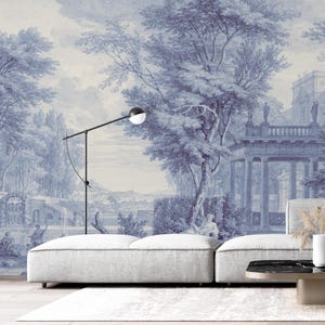 Puede incluir: Un mural azul y blanco que representa una escena de paisaje clásico con árboles, edificios y figuras. Una lámpara de pie negra moderna con una luz esférica está frente al mural. Un sofá blanco y una mesa de centro negra y marrón están en primer plano.