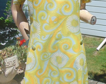 May include: A vintage 1960s style dress with a yellow and white floral pattern. The dress has a short sleeve and a fitted bodice. The fabric is a light weight cotton blend.