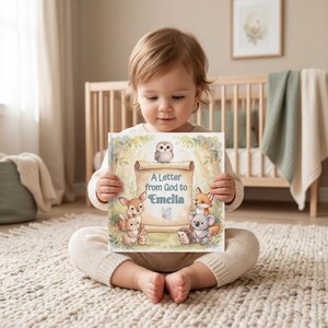 May include: A square hardcover book titled A Letter from God to Emelia, featuring a central parchment scroll illustration surrounded by a cartoon owl, deer, rabbit, fox, koala, and hedgehog in a soft-toned forest setting with light green foliage.