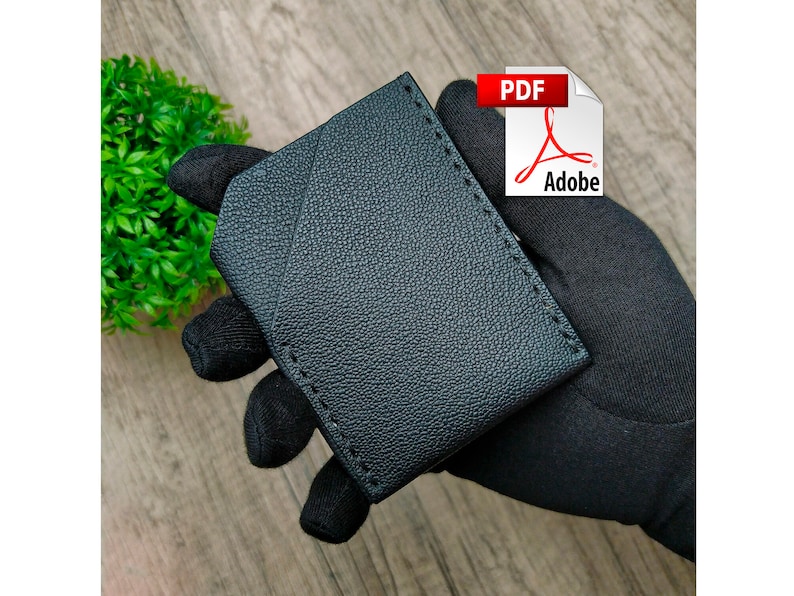 May include: Black leather wallet with a stitched edge. The wallet is folded in half and has a smooth, textured surface.