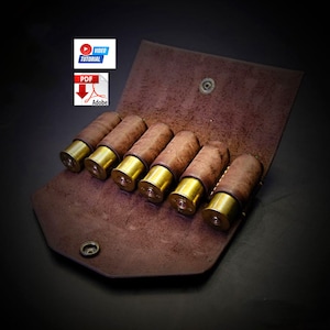 May include: A brown leather shotgun shell holder with six brass-bottomed shells. The holder is open, revealing the shells, and has a snap closure. The image also includes icons for a video tutorial and a PDF document.