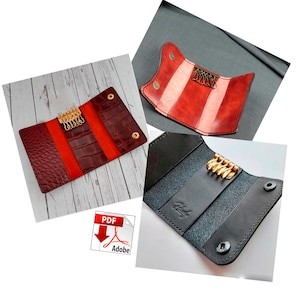 May include: Three leather key holders in different designs. One is burgundy with a textured pattern and red interior. Another is red and white striped. The third is dark gray with a stamped logo.