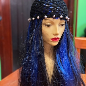 May include: A black mesh hair net with silver beads around the edge. The hair net is on a mannequin with long blue and black hair.