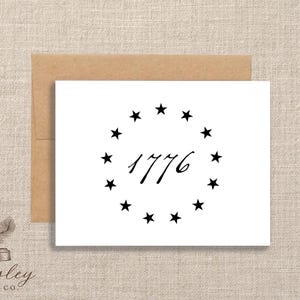May include: White card with a brown envelope featuring a black circle of stars around the number "1776". The card has a simple, elegant design, perfect for patriotic or historical themes. The Paisley Label Co. logo is in the bottom left corner.