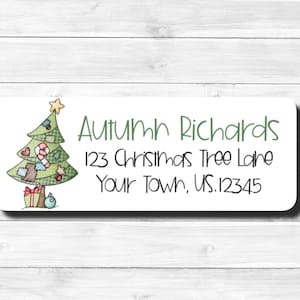May include: A white return address label with a green Christmas tree illustration. The label has the text "Autumn Richards", "123 Christmas Tree Lane", and "Your Town, US.12345".