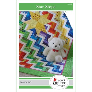 Puede incluir: Un patrón de colcha colorido llamado "Star Steps" con un oso de peluche blanco sentado encima. La colcha mide 50 1/2 pulgadas por 64 pulgadas.