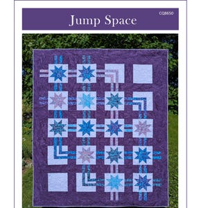 Puede incluir: Un edredón Jump Space con fondo morado y patrones de estrellas en tonos azules y blancos. El edredón mide 158,75 cm por 191,77 cm. El texto "Jump Space" está en la parte superior.