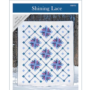 May include: A white quilt with a blue and purple starburst pattern, framed by blue diamond and square accents. The quilt measures 60.5 inches by 72.5 inches. The text "Shining Lace" is at the top, and the Canuck Quilter Designs logo is at the bottom.