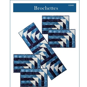 Peut inclure: Un modèle de courtepointe pour un ensemble de sets de table et un chemin de table. Le motif s'appelle "Brochettes" et présente un design géométrique dans des tons de bleu. Les sets de table mesurent 12,5 cm x 18,5 cm et le chemin de table mesure 12,5 cm x 40,5 cm.