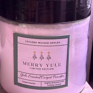 May include: A clear jar with a black lid filled with white powder. The label reads "MERRY YULE LIMITED EDITION" and "Yule Scented Carpet Powder". The label also says "Highly Scented with holiday smells". The product is from Taylors Wicked Apples.