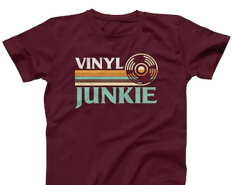 May include: A maroon t-shirt with a vintage-style design featuring a record with the text "VINYL JUNKIE" in a retro font.