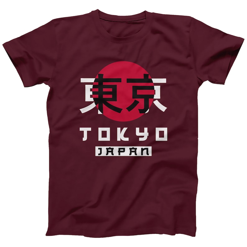 May include: A maroon t-shirt with a white graphic design featuring the Japanese characters for Tokyo, the word "Tokyo" in white block letters, and the word "Japan" in white block letters. The graphic also includes a red circle with a white outline.