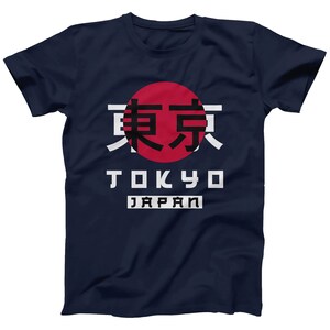 May include: A navy blue t-shirt with a red circle and the Japanese characters for Tokyo in black. The words "Tokyo" and "Japan" are printed in white below the circle.