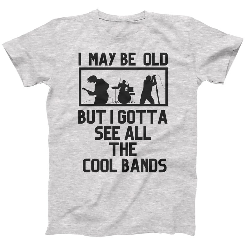 K&ouml;nnte beinhalten: Graues T-Shirt mit einer schwarzen Grafik einer Band, die Musik spielt. Der Text auf dem T-Shirt lautet "I may be old but I gotta see all the cool bands."