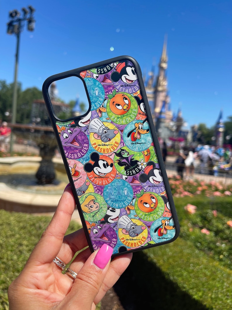 May include: A black phone case with a colorful design featuring various Disney characters and the text "Passholder".