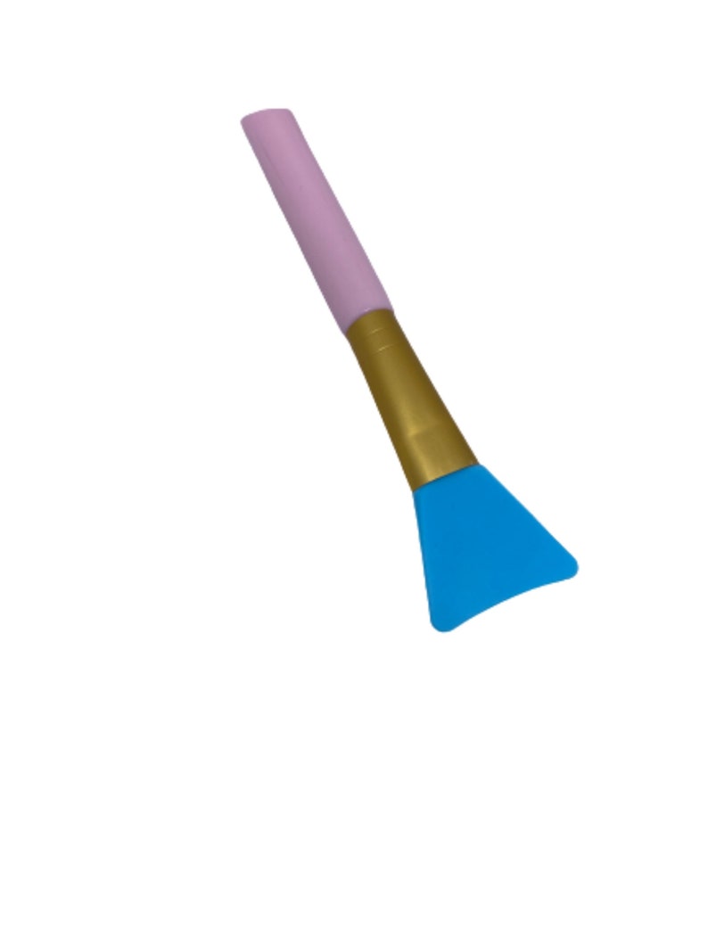 Pu&ograve; includere: Uno spazzolino per il viso in silicone con manico rosa e dorato e una testa triangolare blu.