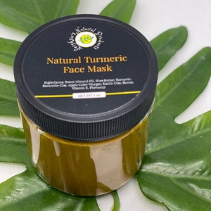 Pu&ograve; includere: Un barattolo di vetro con un coperchio nero che contiene una maschera per il viso naturale al curcuma. Il barattolo &egrave; etichettato "Natural Turmeric Face Mask" e elenca gli ingredienti: olio di mandorle dolci, burro di karit&egrave;, curcuma, argilla bentonite, aceto di sidro di mele, argilla caolino, miele, vitamina E, fenossietanolo. Il barattolo &egrave; appoggiato su una foglia verde.