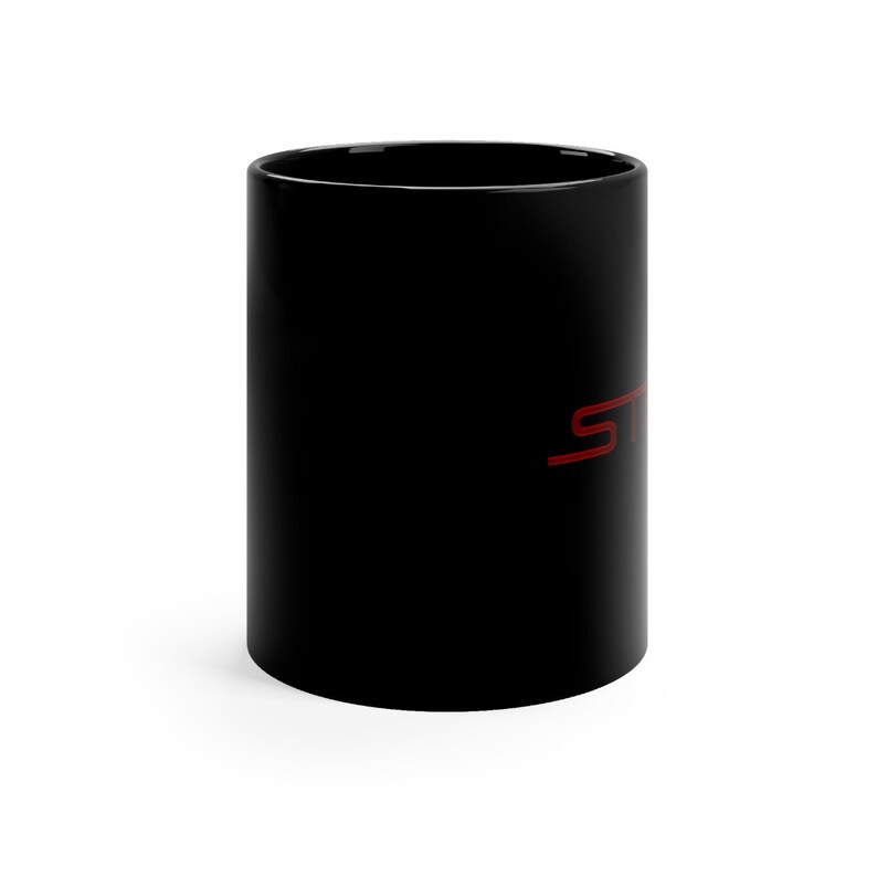 May include: Black ceramic coffee mug with a red "ST" logo.