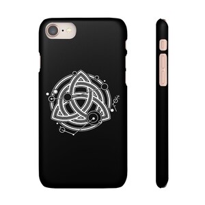 Puede incluir: Una funda negra para iPhone con un dise&ntilde;o geom&eacute;trico blanco que presenta un nudo celta estilizado y un c&iacute;rculo con puntos alrededor.