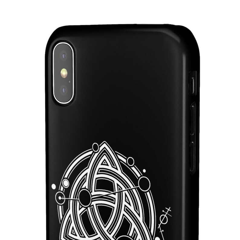 Puede incluir: Carcasa de tel&eacute;fono negra con un dise&ntilde;o geom&eacute;trico blanco que presenta un c&iacute;rculo con un patr&oacute;n de nudo celta y c&iacute;rculos m&aacute;s peque&ntilde;os alrededor.