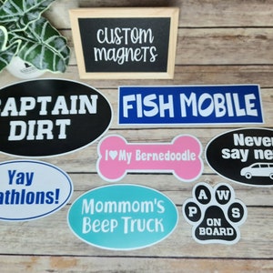 Pu&ograve; includere: Un set di otto magneti ovali e a forma di osso con varie frasi e disegni. I magneti sono neri, blu, rosa, bianchi e turchese. Le frasi includono "Captain Dirt", "Fish Mobile", "Never Say Never", "I &hearts; My Bernedoodle", "Yay Triathlons!", "Mommom's Beep Truck" e "Paws On Board".